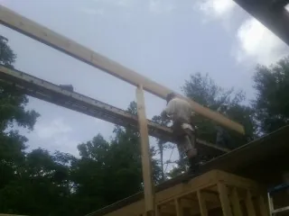 Carpenter setting a ridge beam over a new addition frame — Ice Dam Removal by Roofing Brothers in Arvilla