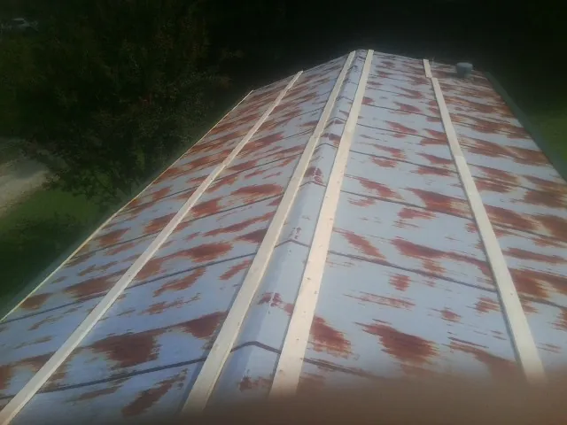Rusted metal roof panels with new wood purlins before replacement — Storm Damage Roof Repair in Arvilla by Roofing Brothers